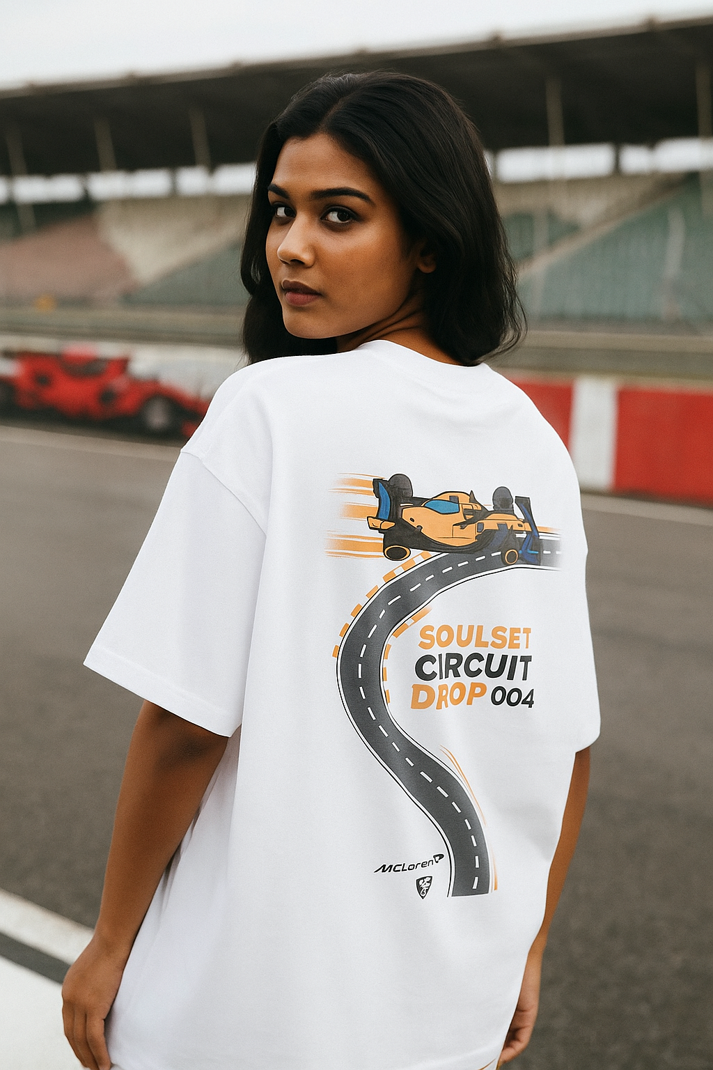 Person wearing a white t-shirt with a race car graphic and text on a track background