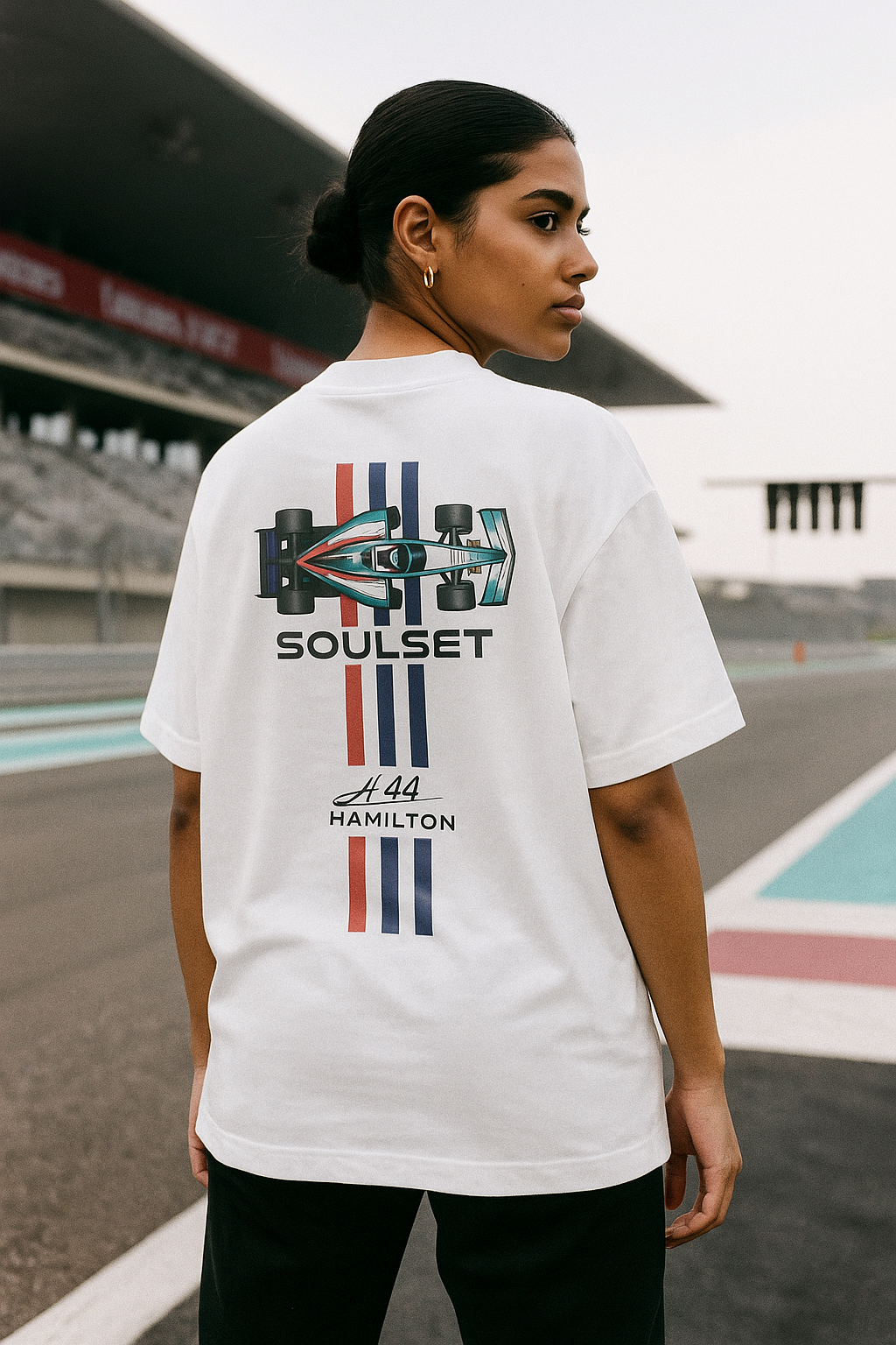 Person wearing a white t-shirt with 'Soulset' design on a race track background