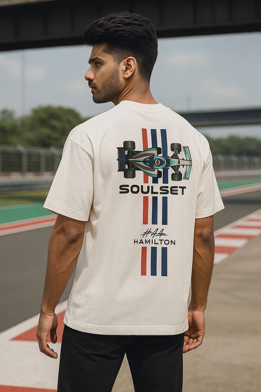 Men wearing oversized beige F1-inspired SoulSet t-shirt with #44 graphic at a racetrack – stylish motorsport streetwear by SoulSet.Store