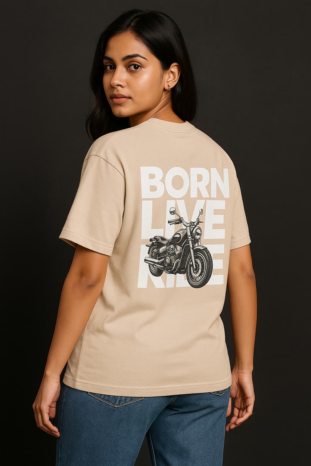 Person wearing a beige t-shirt with a motorcycle graphic and text on the back against a dark background