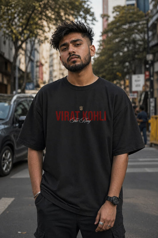 Man wearing a black t-shirt with 'Virat Kohli' text on a city street