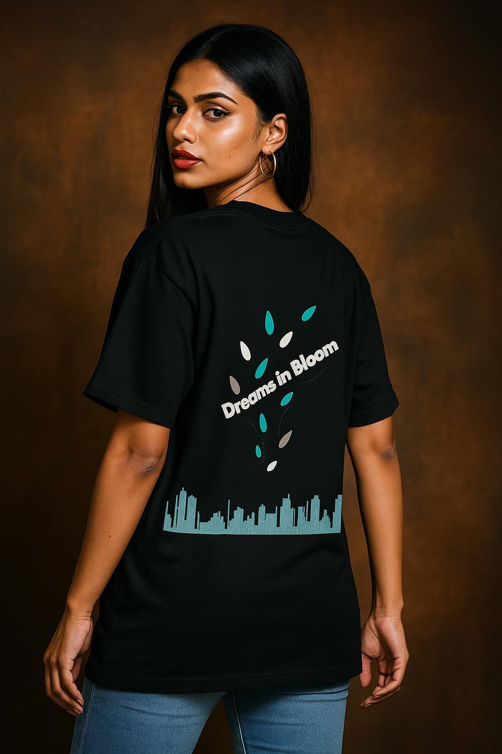Woman wearing a black t-shirt with 'Dreams in Bloom' design on a brown background