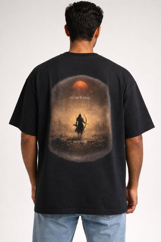 Person wearing a black t-shirt with a graphic design on the back, standing against a white background