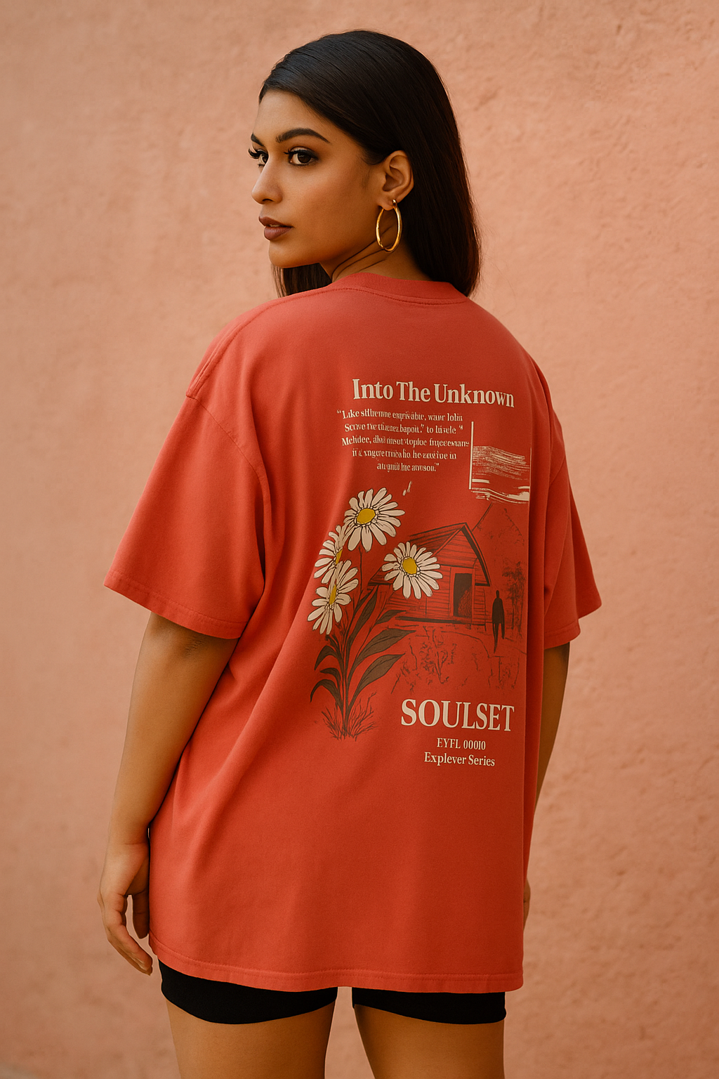 Person wearing a red t-shirt with floral design and text on a pink background