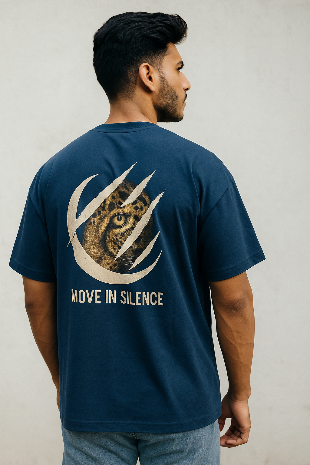 Man wearing a navy blue t-shirt with a leopard design and text on the back against a plain background