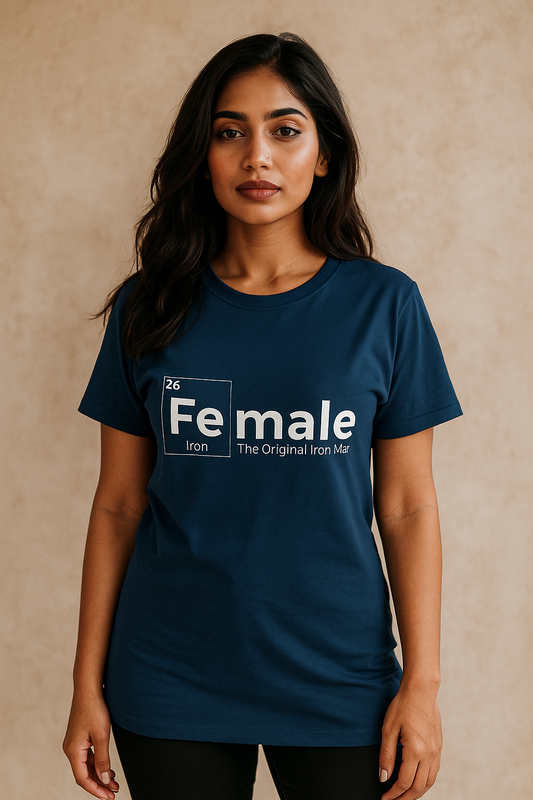 Confident young Indian female model in navy blue oversized T-shirt with ‘Female Iron – The Original Iron Man’ white print, posing stylishly against beige wall. E-commerce fashion mock-up for women’s clothing.