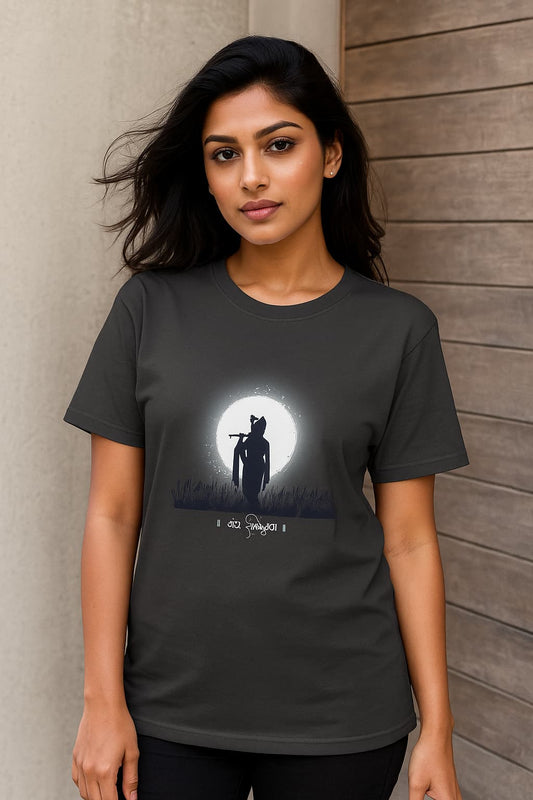 Confident young Indian woman in her 20s wearing a black oversized T-shirt with Krishna silhouette against full moon and Hindi text, styled for e-commerce fashion photoshoot.