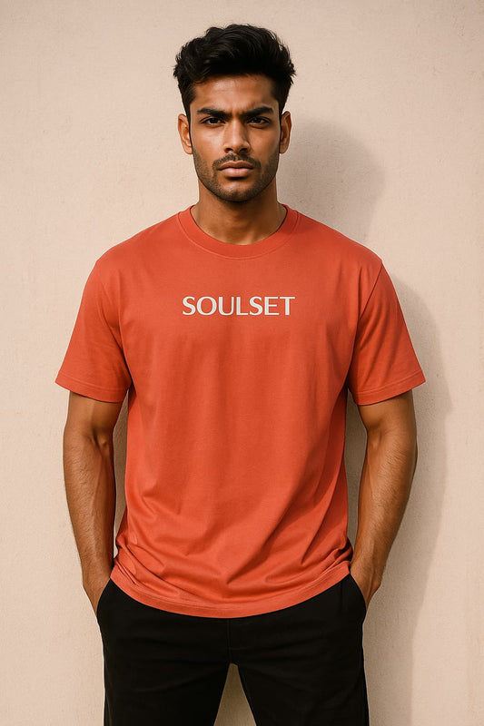 Man wearing a red 'Soulset' t-shirt against a beige background