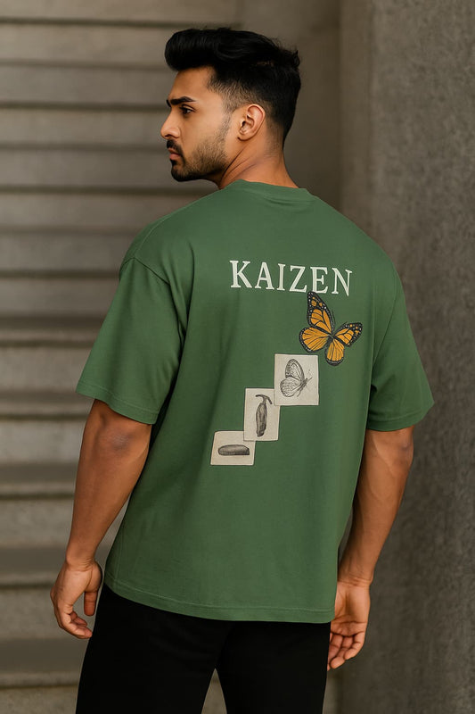Man wearing a green t-shirt with 'KAIZEN' and butterfly illustrations on the back.