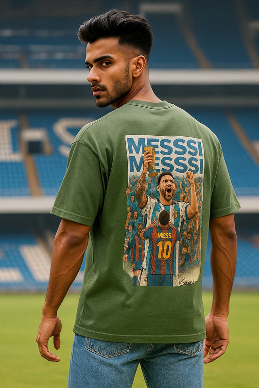 Man wearing a green t-shirt with a graphic of a soccer player and 'Messi' text, standing on a soccer field.