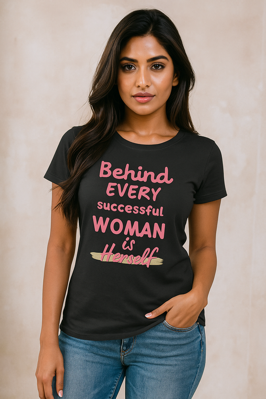 Woman wearing a black t-shirt with pink text on a beige background- BEHIND EVERY SUCCESFUL WOMAN IS HERSELF