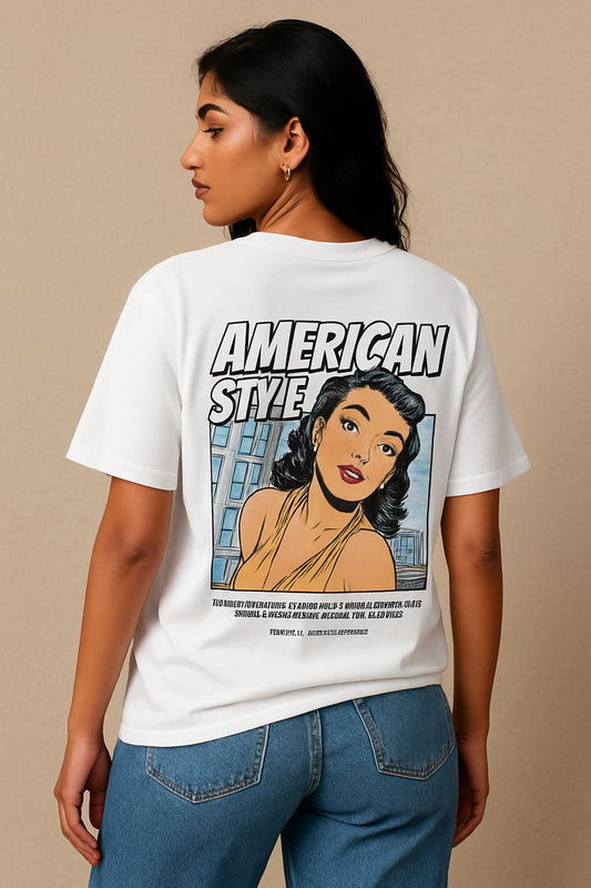 Person wearing a white t-shirt with a graphic design and text on the back, standing against a beige background.