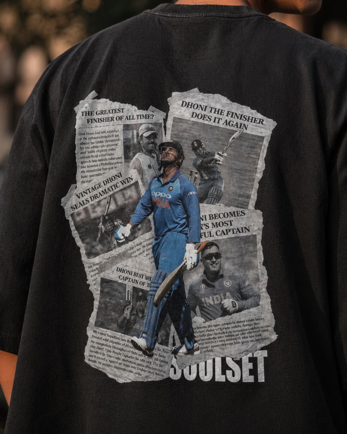 Black t-shirt with sports-themed graphic and text on a blurred background
