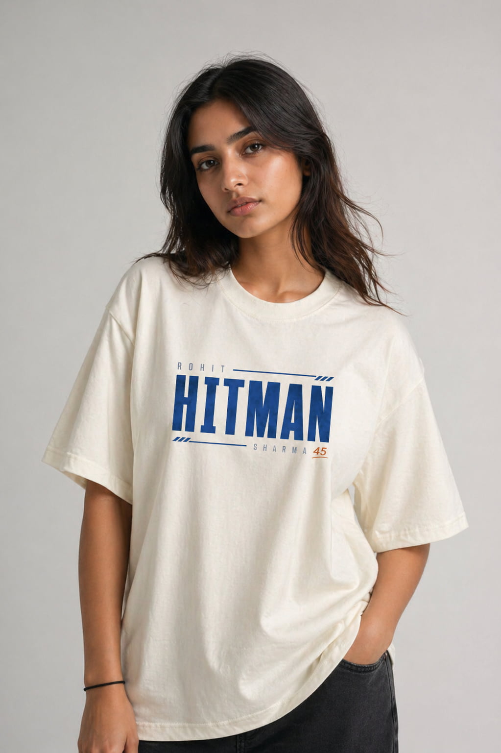 Woman wearing a cream t-shirt with 'HITMAN' branding on a gray background