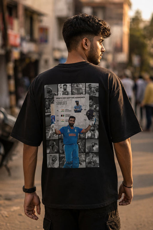 Person wearing a black t-shirt with a collage of images on the back, standing in an outdoor setting.