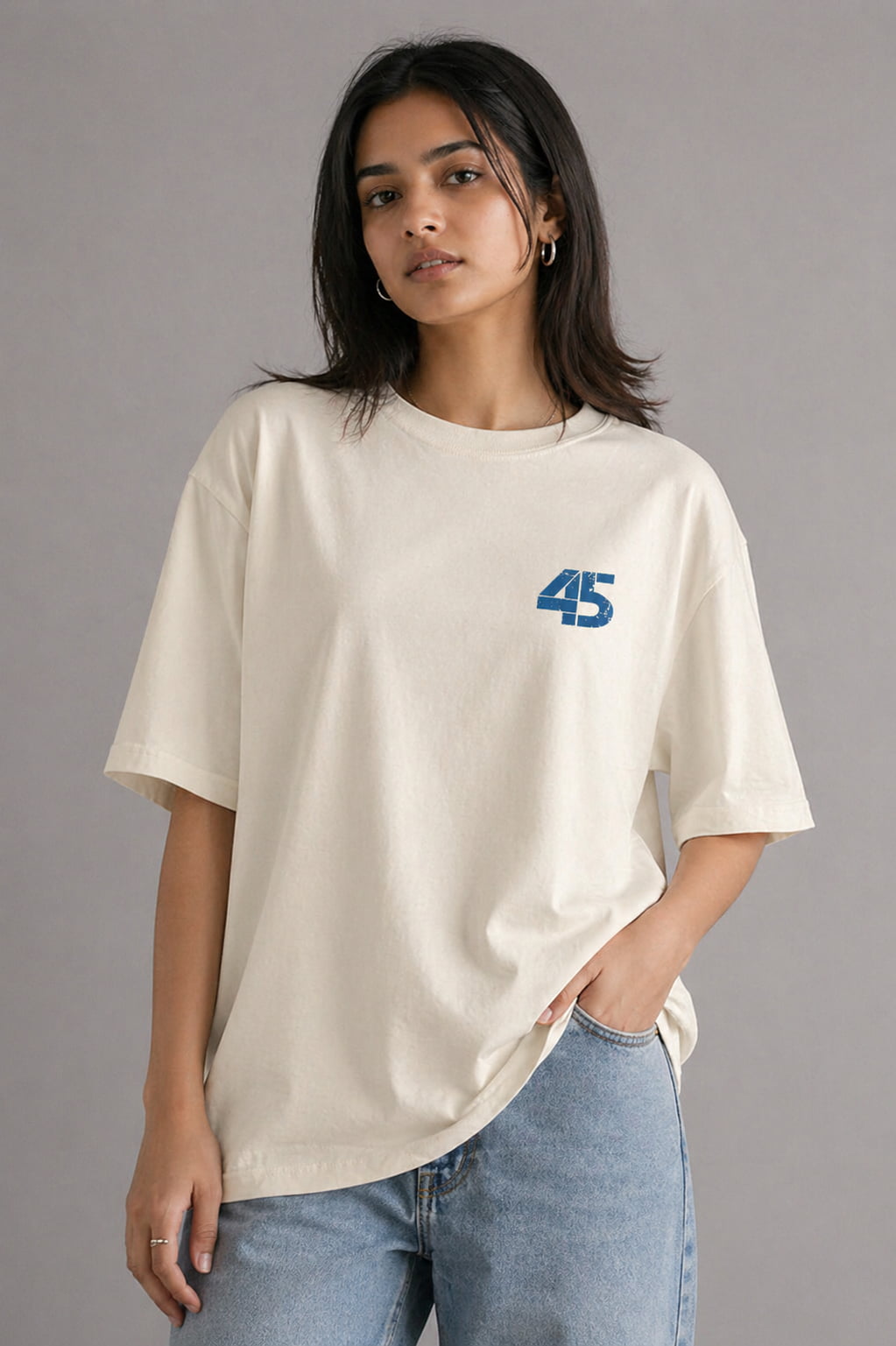Person wearing a beige t-shirt with a blue number 45 design on a gray background