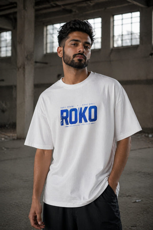 Man wearing a white t-shirt with 'ROKO' printed on it in an industrial setting