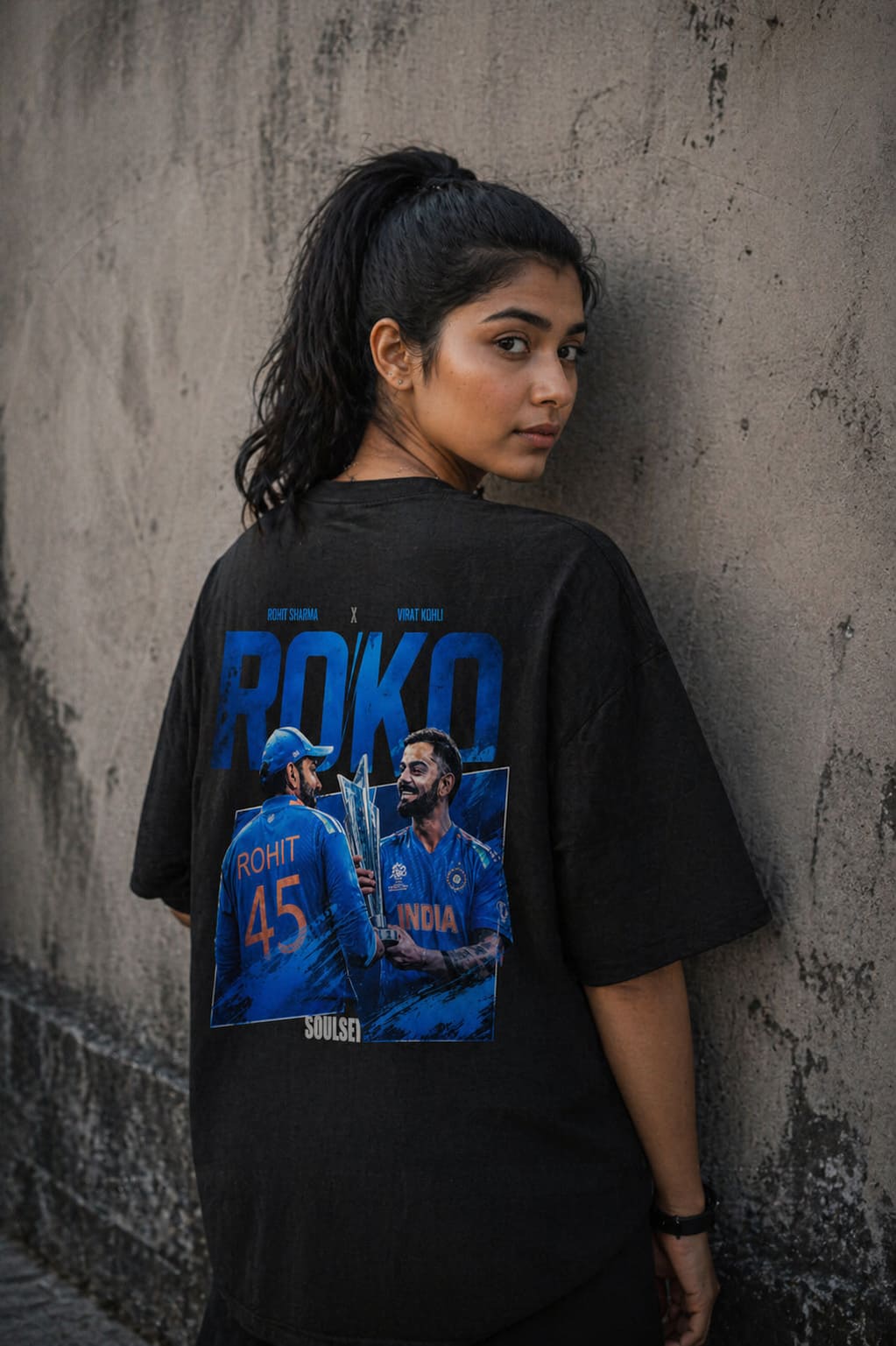 Person wearing a black t-shirt with sports-themed graphics and text.