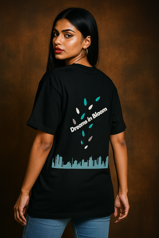 Woman wearing a black t-shirt with 'Dreams in Bloom' design on a brown background