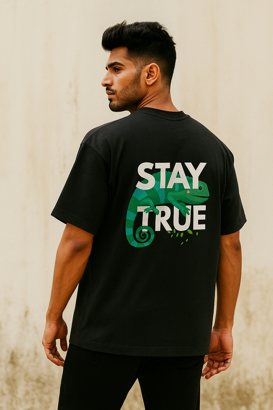Indian male model in black oversized T-shirt showing back design with chameleon and “Stay True” text – stylish streetwear fashion