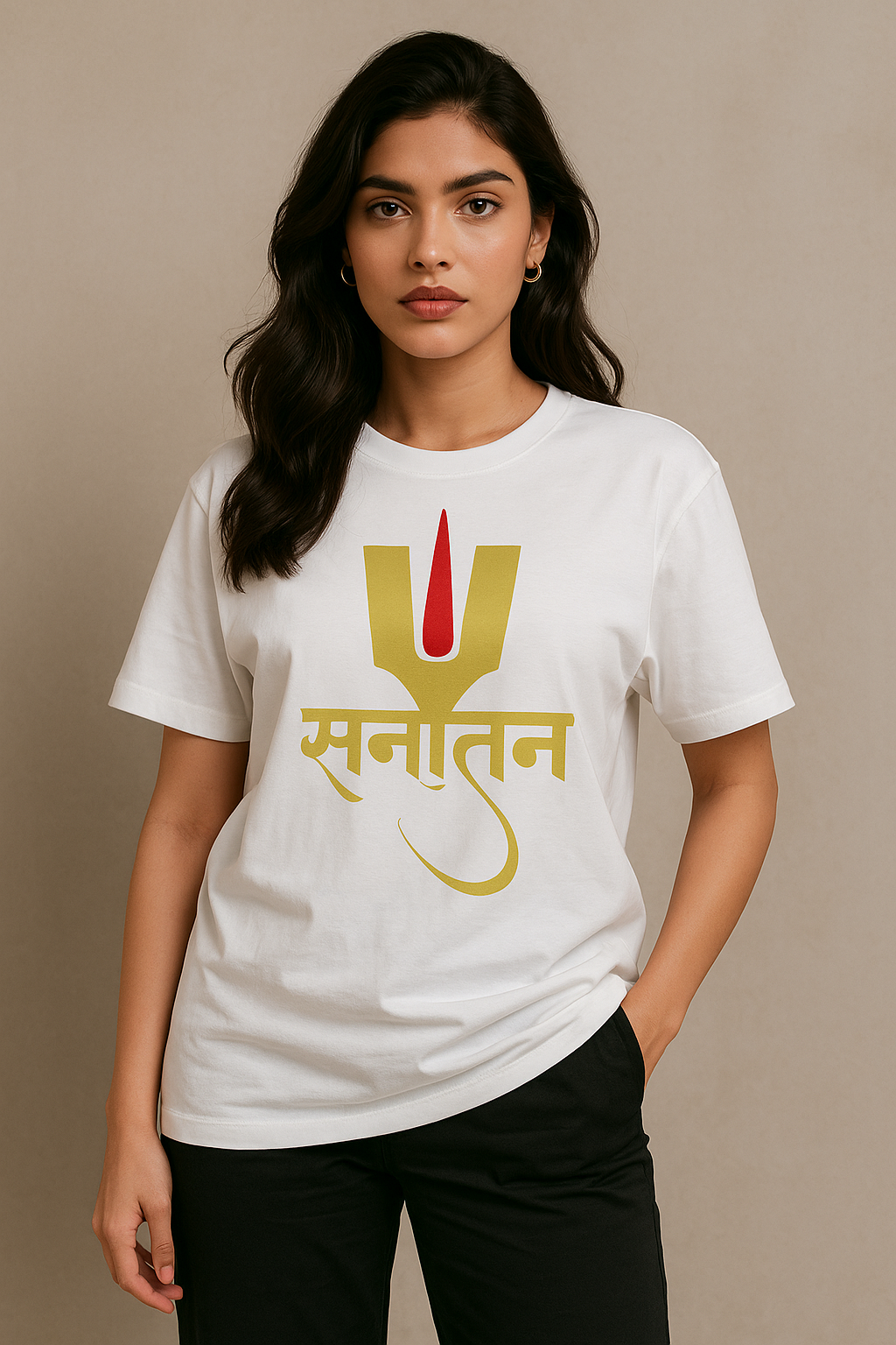 A confident young Indian woman wearing a white oversized T-shirt with a golden-yellow and red 'Sanatan' design in Devanagari script, posing against a beige background with one hand in her pocket.