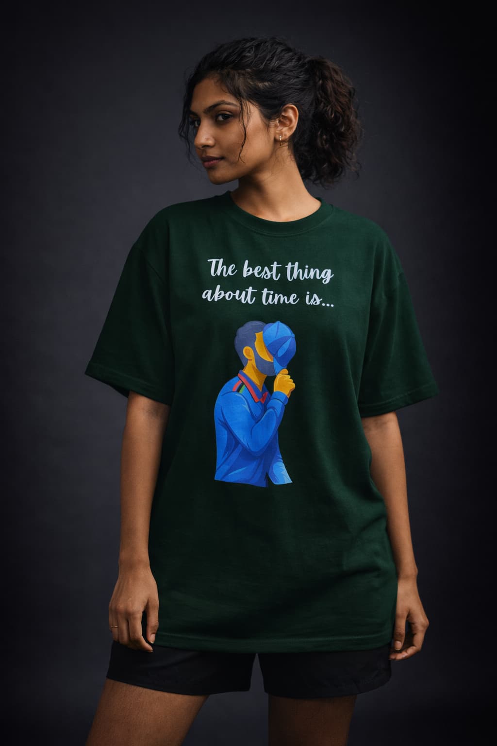 Person wearing a green t-shirt with a graphic and text on a dark background