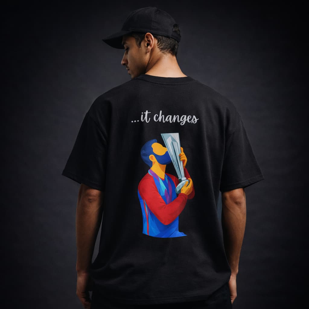 Person wearing a black t-shirt with a colorful graphic and text on the back against a dark background