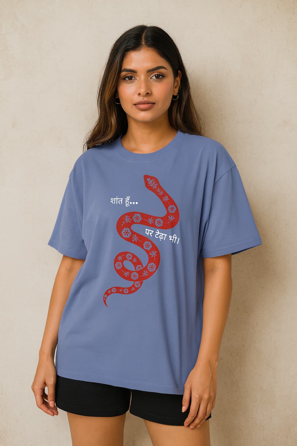 Woman wearing a blue t-shirt with a red snake design and text on a beige background