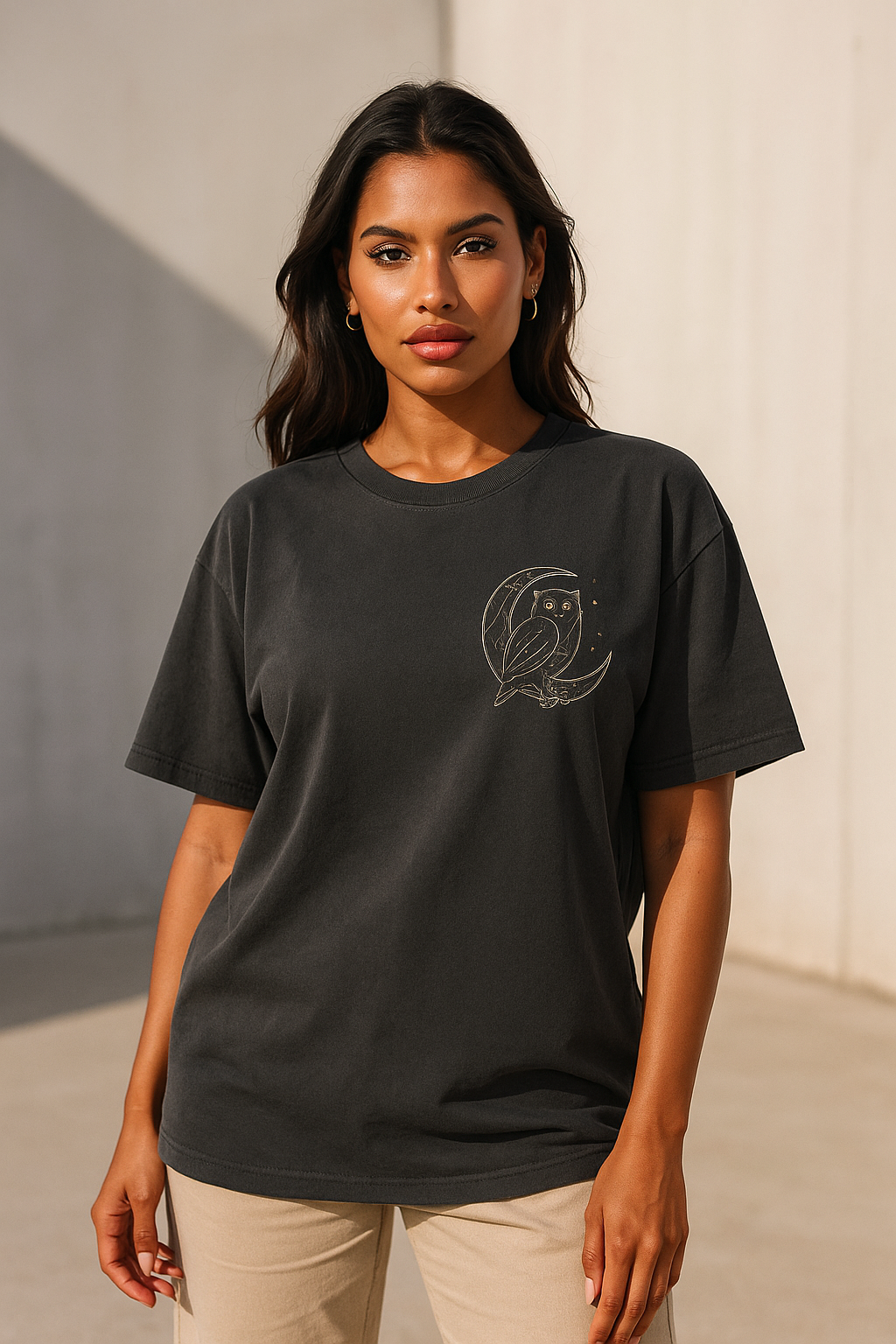 Woman wearing a black t-shirt with a logo on a neutral background