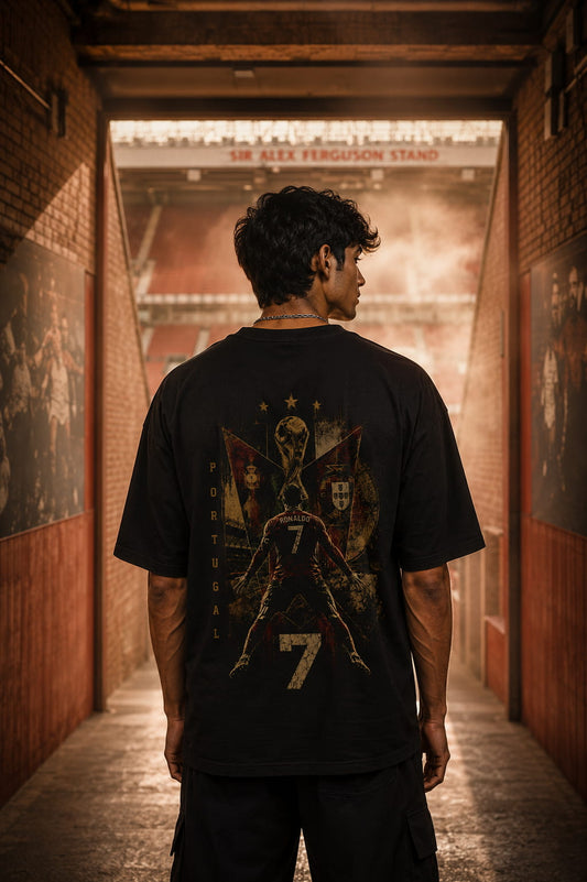 Person wearing a black t-shirt with a graphic design in a stadium hallway