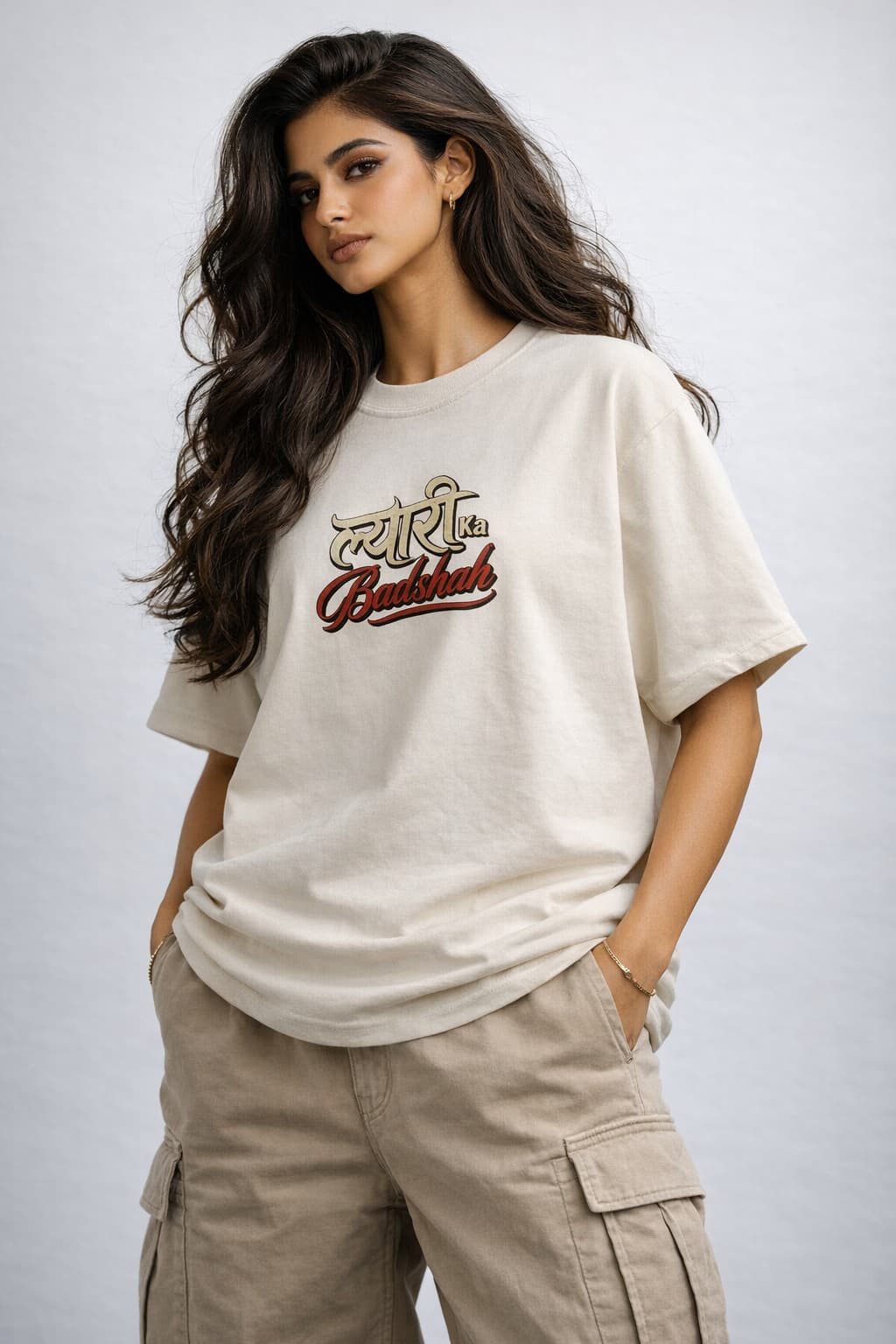 Woman wearing a beige t-shirt with text and cargo pants on a plain background