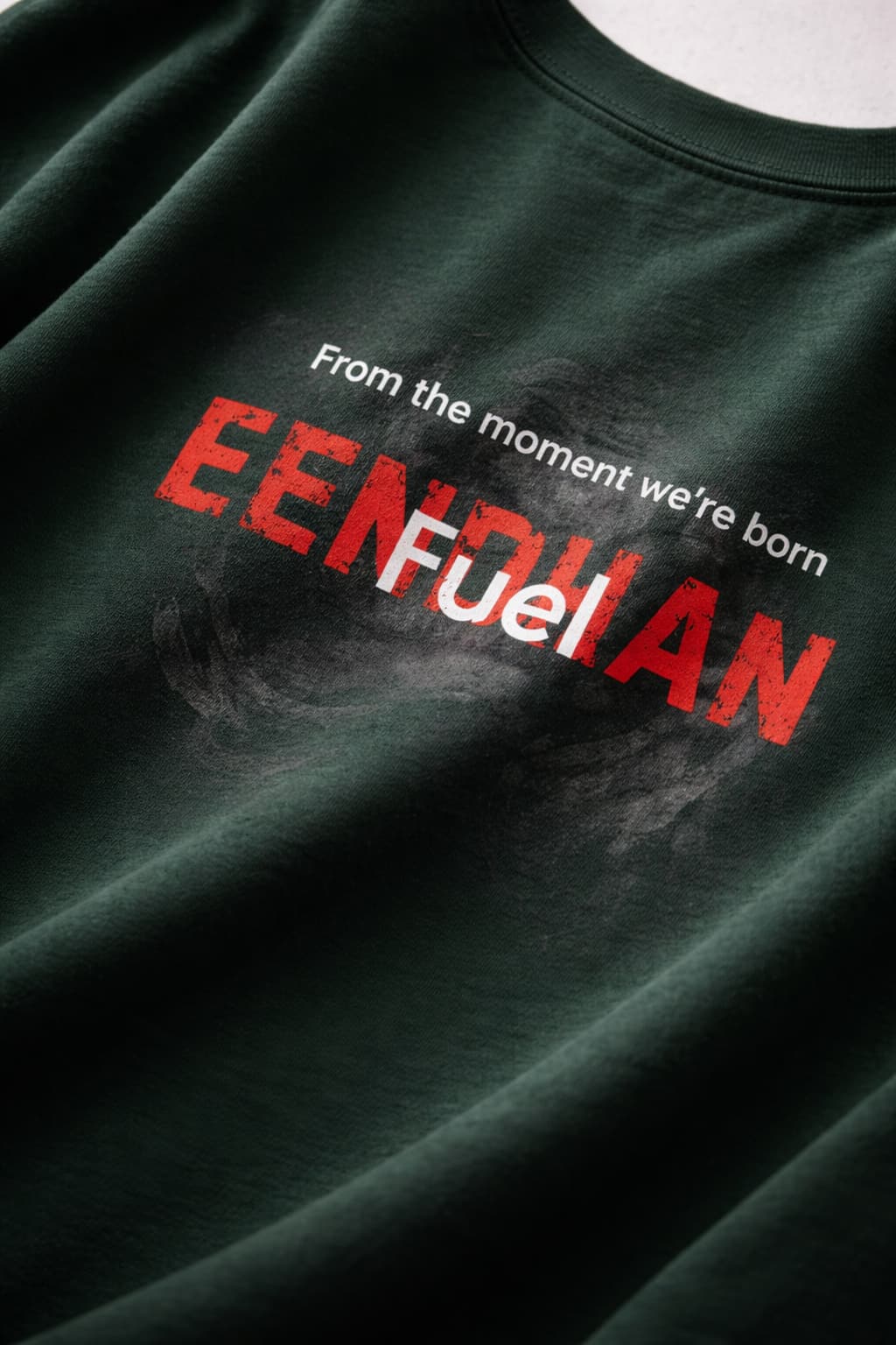 Dark green t-shirt with red and white text on a plain background