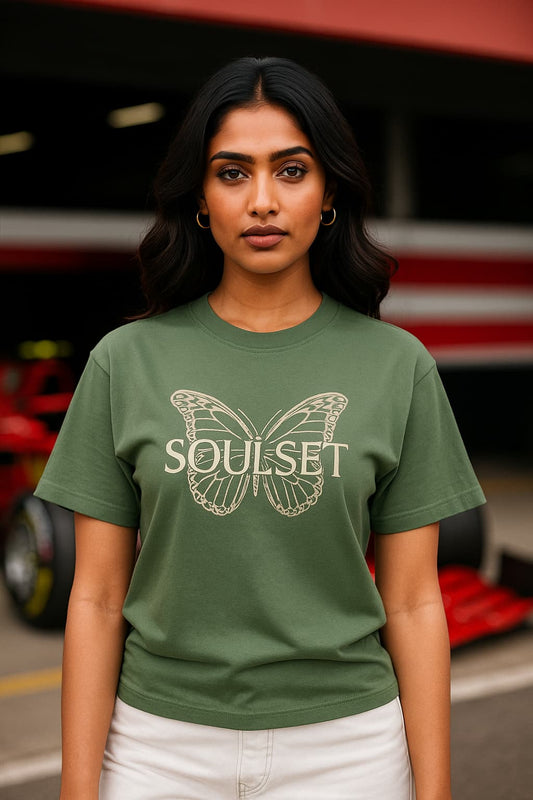 Person wearing a green t-shirt with 'Soulset' design in front of a red vehicle.