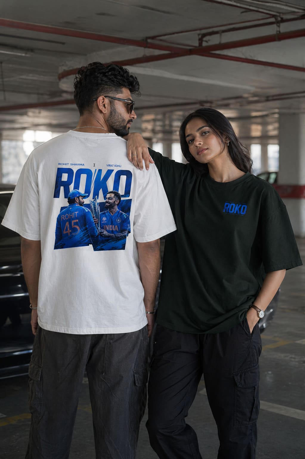 Two people wearing t-shirts with 'ROKO' branding in a parking garage.