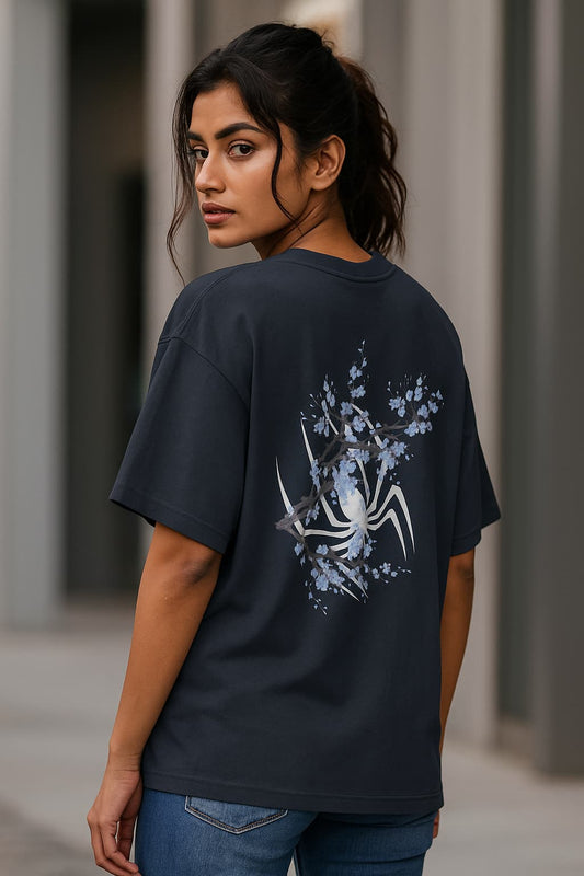 Woman wearing a black t-shirt with a spider design outdoors