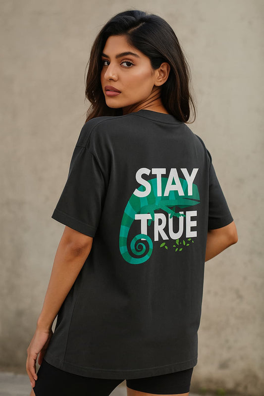 Woman wearing a black t-shirt with 'Stay True' graphic on the back against a neutral background